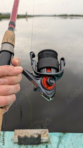 Obraz na płótnie Hand holding fishing rod and reel, fishing at Corrib river at Galway, Ireland, spinning, angling, catch and release, sport and leisure, nature background w salonie