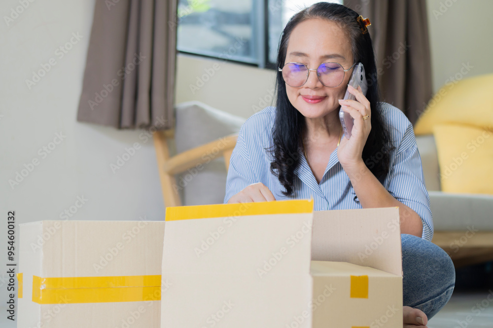 Positive mature customer woman unpacking paper box at home, getting purchase from Internet store Positive mature customer woman unpacking paper box at home, getting purchase from Internet store