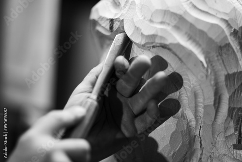 Artist carving wooden statue using chisel in workshop photo