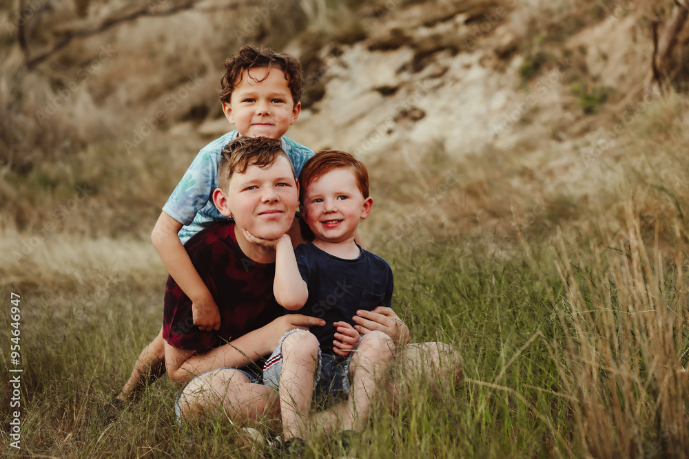 Three brothers sitting together on a rock in the Australian bush Three brothers sitting together on a rock in the Australian bush