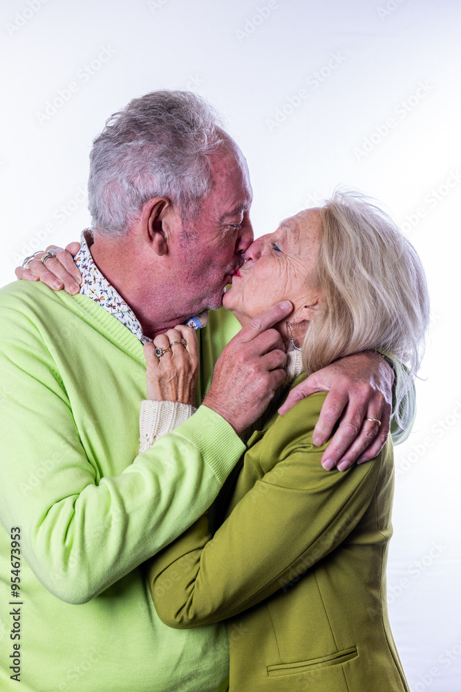 An elderly couple sharing a tender kiss in colorful attire, showcasing their love and deep affection An elderly couple sharing a tender kiss in colorful attire, showcasing their love and deep affection