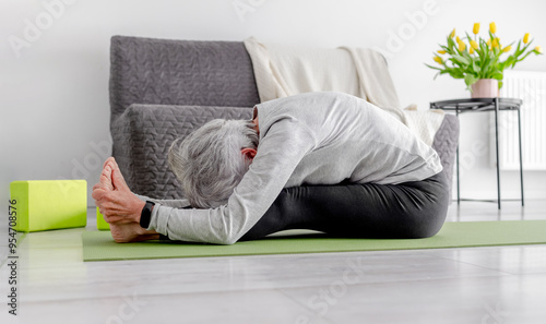 Εκτύπωση καμβά Sporty Lifestyle In Retirement, A Sweet Grey-Haired Woman Exercises On The Livin