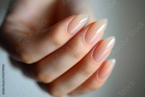 Female hand with neutral nails. Female manicure with light natural color nails, woman showing fresh perfect manicure with nude pink nail polish, gel nails made at luxury beauty salon