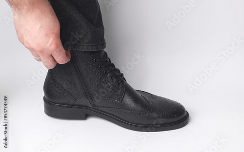 Male leg in black leather brogue boot on a white background photo