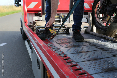Dépanneur en train d'attacher une moto sur la dépanneuse