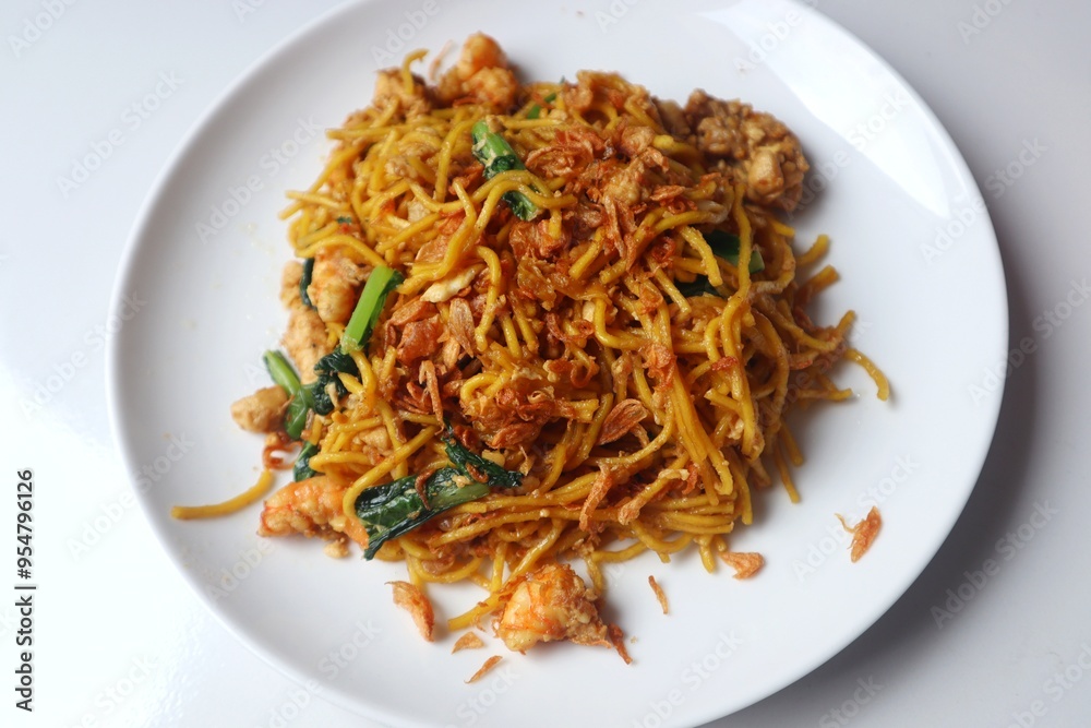 Delicious fried yellow noodles on a white plate close up view. Delicious fried yellow noodles on a white plate close up view.