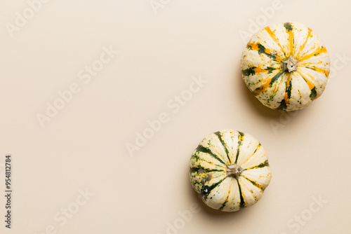 Autumn composition of little orange pumpkins on colored table background. Fall, Halloween and Thanksgiving concept. Autumn flat lay photography. Top view vith copy space photo