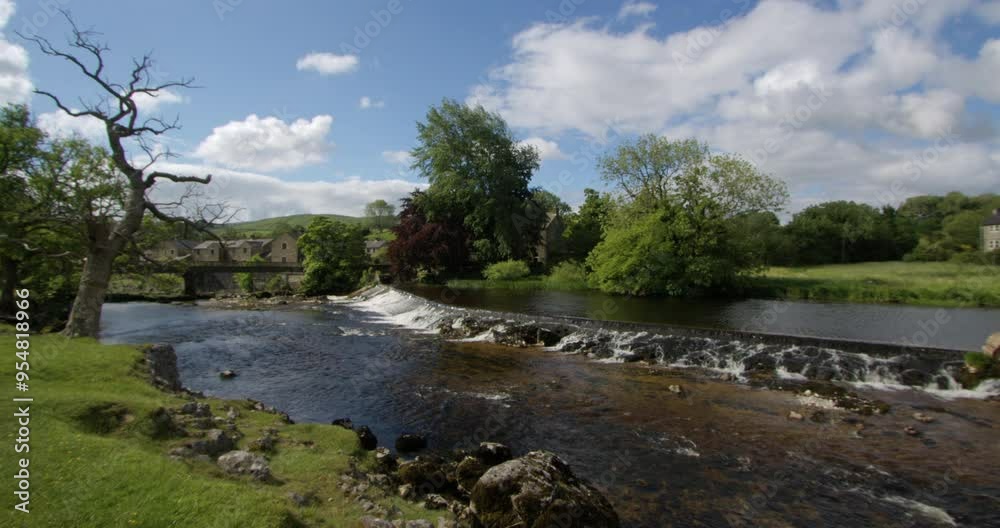 Extra Wide Shot looking down the river Wharfe and the control weir with Linton falls in the background in the Yorkshire Dales Extra Wide Shot looking down the river Wharfe and the control weir with Linton falls in the background in the Yorkshire Dales