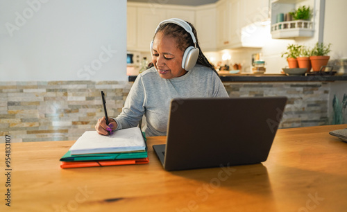 Senior african woman doing digital webinar from home - Joyful elderly lifestyle and technology concept - Focus on face photo