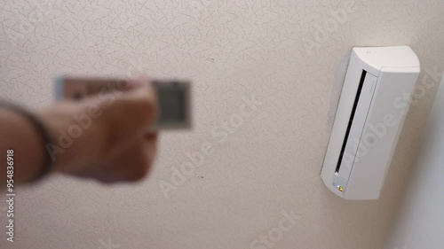 Hand operating air conditioner remote control photo