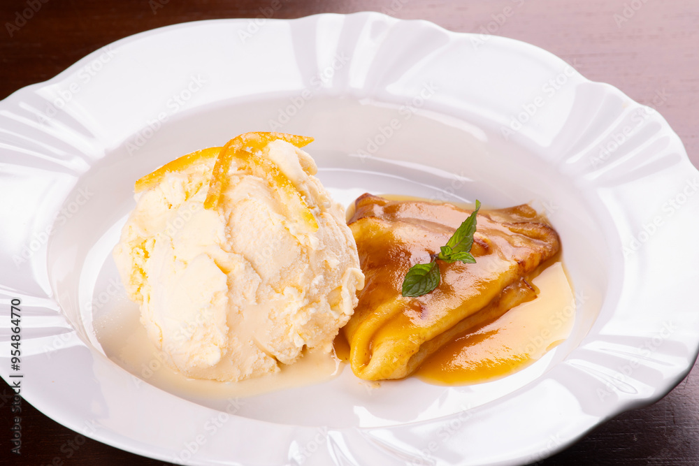 crepe suzette dessert with scoop of vanilla ice cream and orange slices close up crepe suzette dessert with scoop of vanilla ice cream and orange slices close up