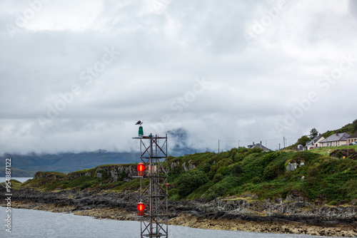 Signal tower in Mallaig harbour with a sea gull on top, Image shows the signal tower with illuminated lights and a seagull standing on top on a cloudy summers morning photo