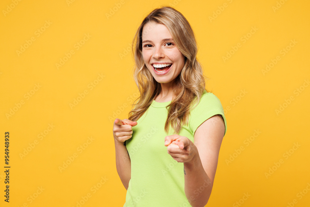 Young happy fun blonde woman she wear green t-shirt casual clothes point index finger camera on you motivating encourage isolated on plain yellow orange background studio portrait. Lifestyle concept. Young happy fun blonde woman she wear green t-shirt casual clothes point index finger camera on you motivating encourage isolated on plain yellow orange background studio portrait. Lifestyle concept.