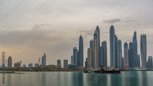 Panorama of modern skyscrapers in Dubai city at sunrise timelapse from the Palm Jumeirah Island.