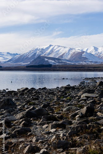 Day view of Lake Tekapo with snowy mountains.