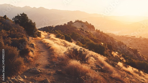 Golden Hour Light Bathes a Dramatic Mountain Landscape with a Winding Trail and Rugged Terrain photo