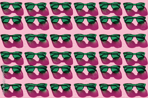 Seameless pattern of green sunglasses on pink background with shadows photo