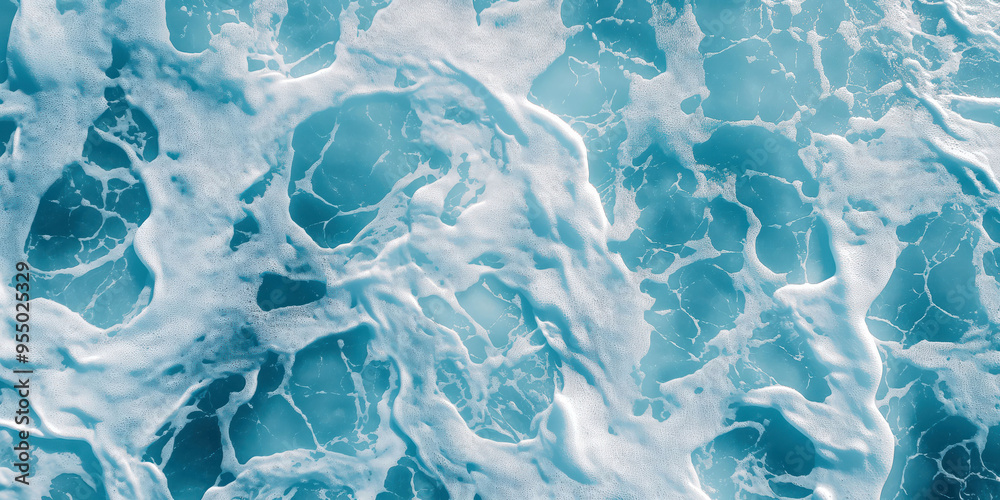 Obraz premium Aerial view of ocean waves and foam patterns in turquoise waters
