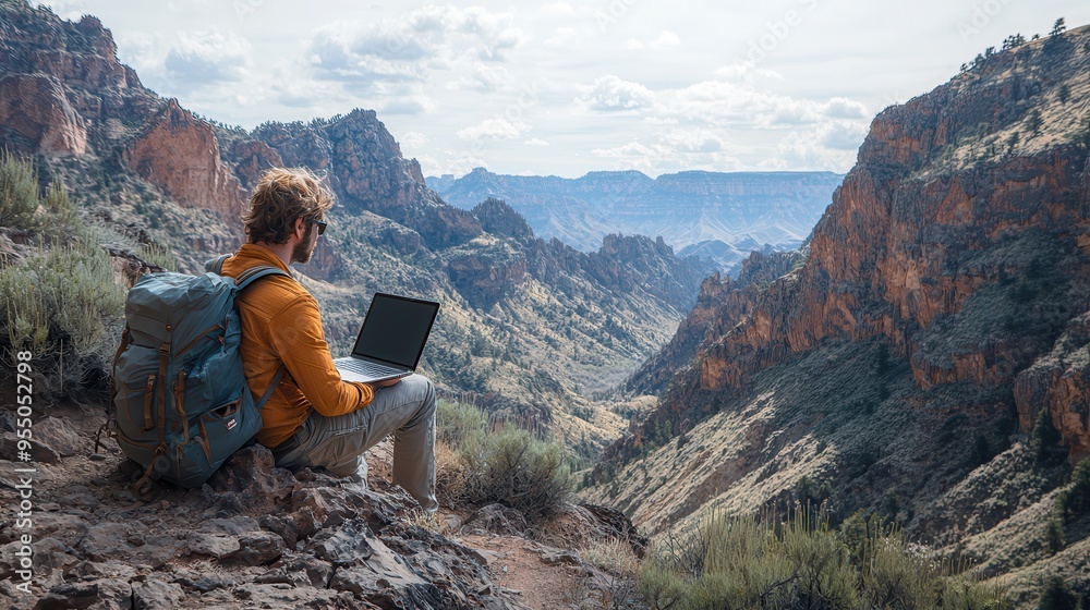 Naklejka premium Remote Work Paradise: Digital Nomad Working on Laptop with Canyon View