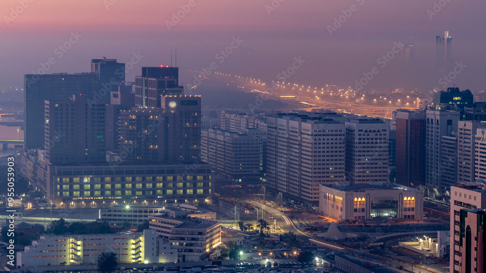 Obraz premium Abu Dhabi city skyline with skyscrapers before sunrise from above night to day timelapse