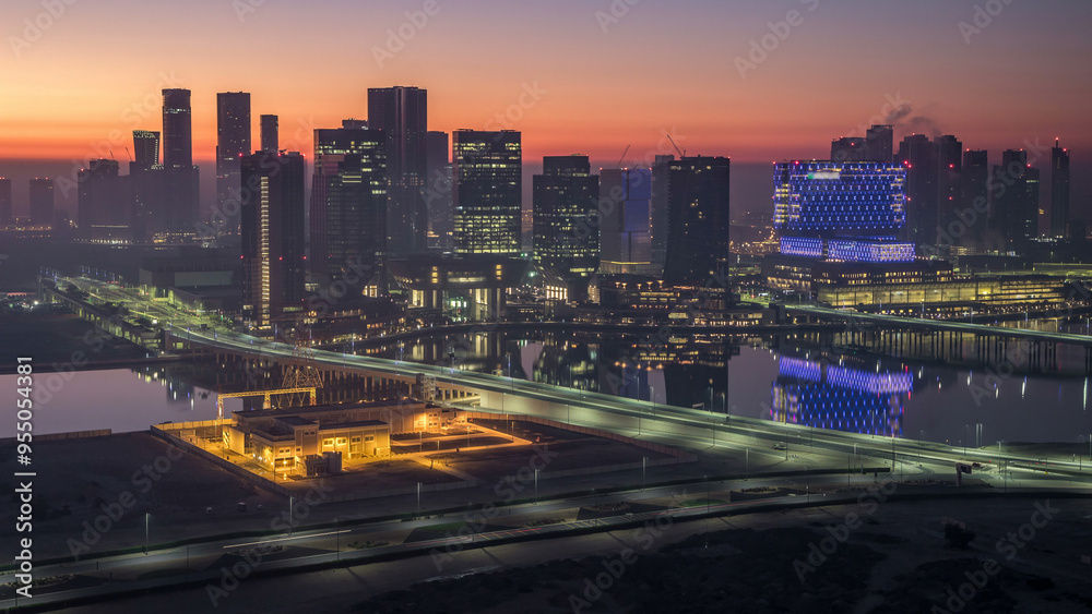 Fototapeta premium Abu Dhabi city skyline with skyscrapers before sunrise from above night to day timelapse