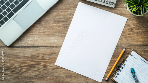 Blank sheet of paper next to pencil, eraser, ruler, modern computer keyboard on wooden office table.