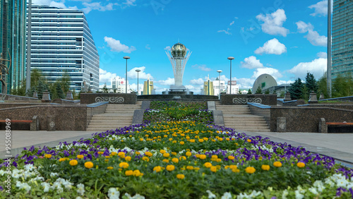 Flowers on Nurzhol Boulevard with Baiterek on background timelapse hyperlapse photo