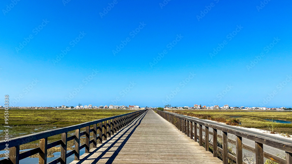 Wooden bridge leading the way to Faro Beach - Praia de Faro, Portugal Wooden bridge leading the way to Faro Beach - Praia de Faro, Portugal
