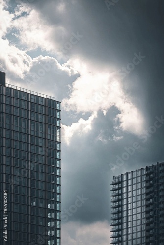 The sharp lines of a distant modern building standing against a cloudy sky, with the urban landscape compressed behind it. 