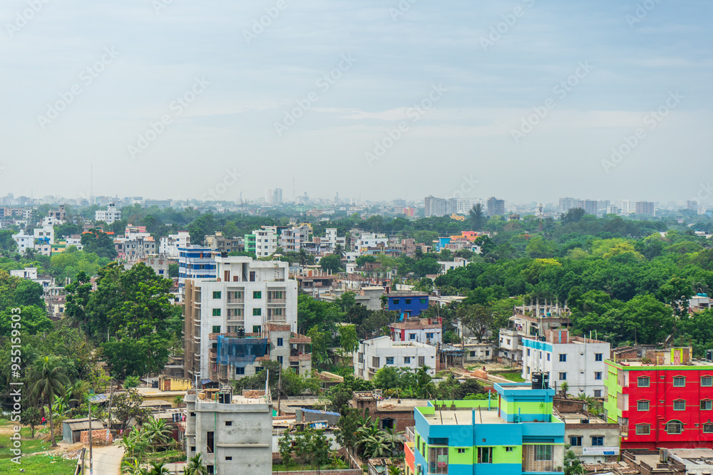cityscape with multiple buildings of varying heights and colors, interspersed with dense vegetation under a hazy sky. Rajshahi, Bangladesh cityscape with multiple buildings of varying heights and colors, interspersed with dense vegetation under a hazy sky. Rajshahi, Bangladesh