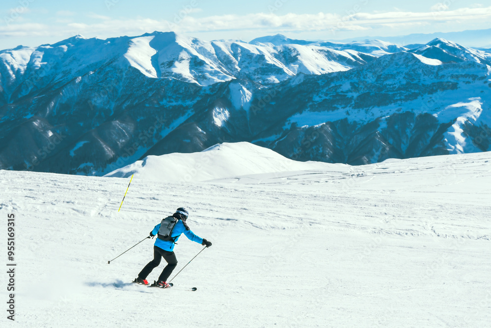 Close up dynamic sports banner of man skier on piste ski downhill fast motion in Alps. Active winter holidays, skiing downhill in overcast day. Ski rides on the track with swirls of fresh snow Close up dynamic sports banner of man skier on piste ski downhill fast motion in Alps. Active winter holidays, skiing downhill in overcast day. Ski rides on the track with swirls of fresh snow