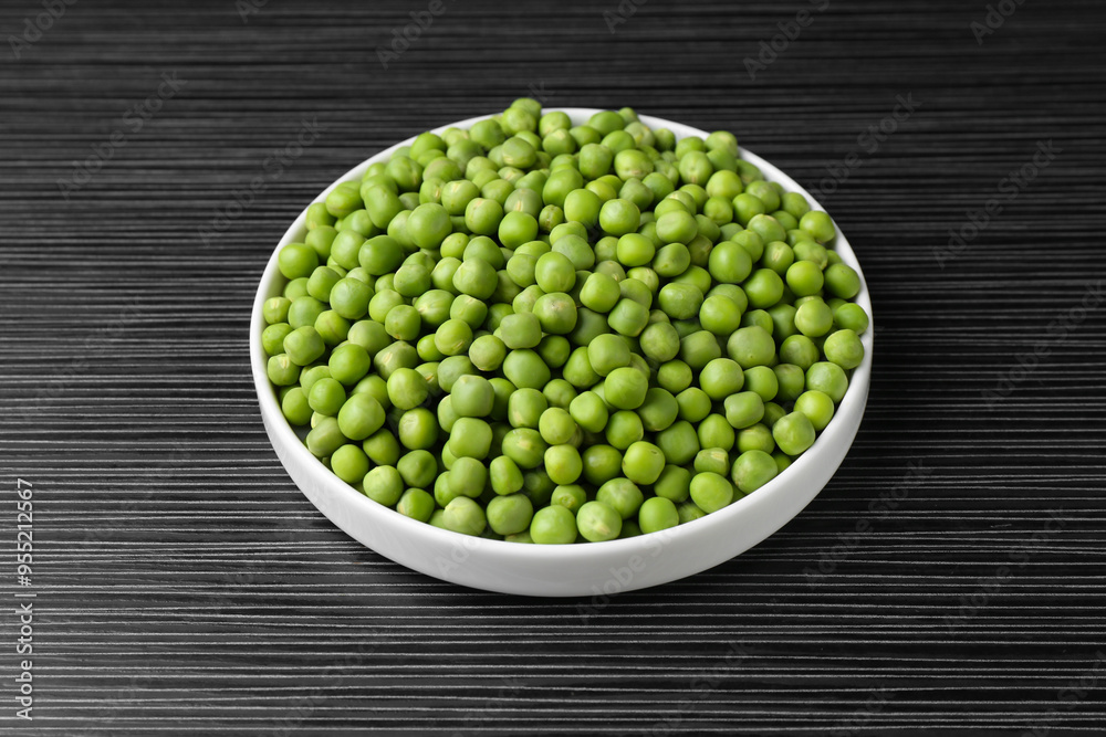 Fresh green peas on black wooden table, closeup Fresh green peas on black wooden table, closeup