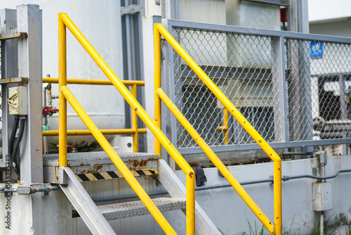 Photos Refinery plant and oil storage metal walkway-stair platform with yellow handrail or banister rail part
