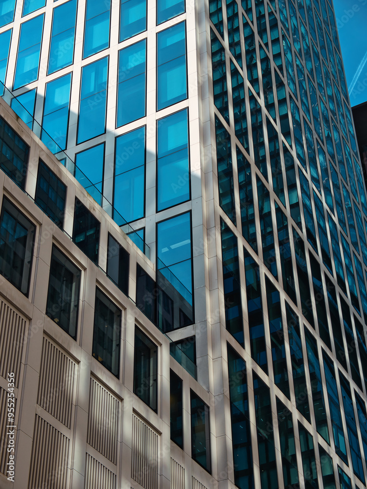 A Detail of a skyscraper with white front and large glass windows with diagonals and vertical lines