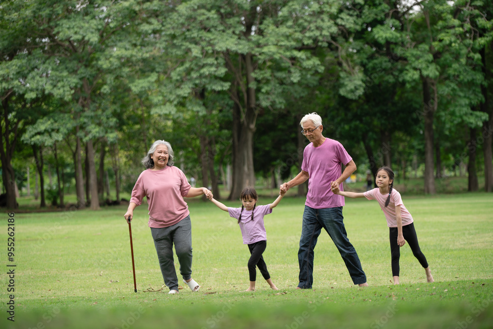 Happy Asian family children having fun and playing with her grandparents in the park Happy Asian family children having fun and playing with her grandparents in the park