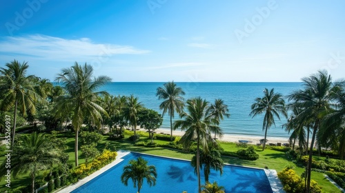 Scenic view from a serviced condominium in Hua Hin, Thailand, overlooking a serene swimming pool, palm trees, and the calm sea under a bright and clear sky