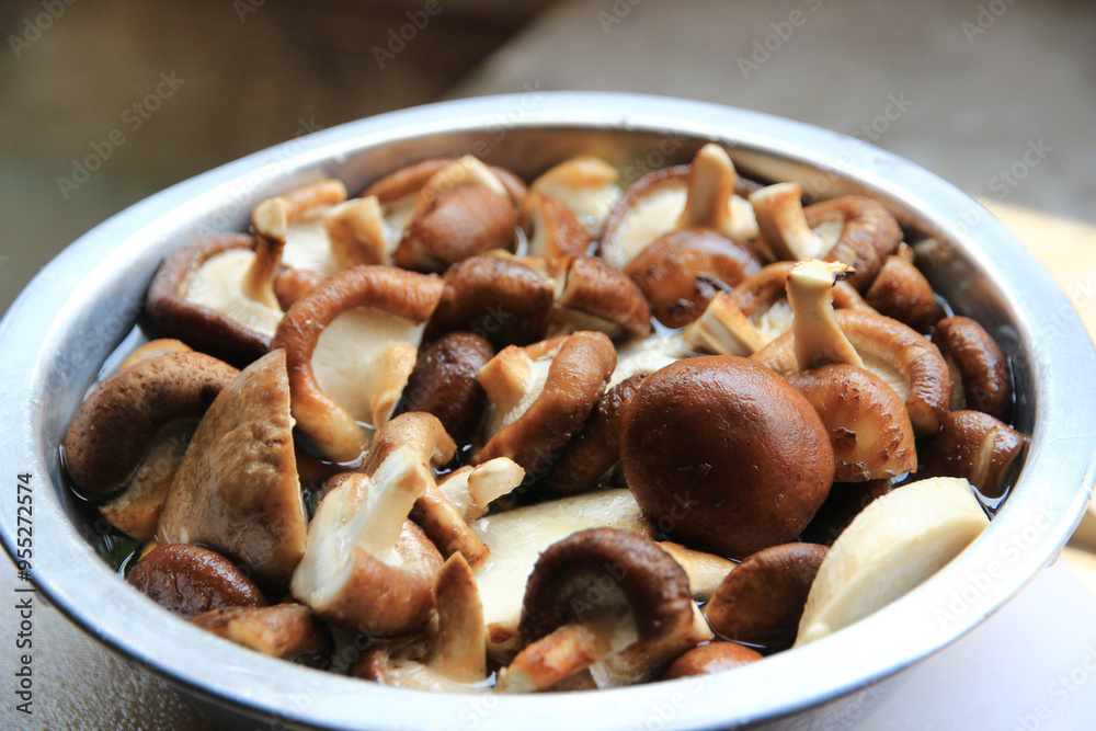 Small mushrooms that have been cut into small pieces are placed in a container and ready to be cooked. Small mushrooms that have been cut into small pieces are placed in a container and ready to be cooked.
