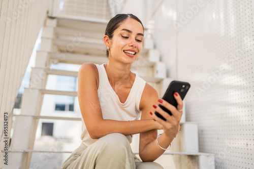 Young happy woman sit on stairs and use mobile phone Free Download Young happy woman sit on stairs and use mobile phone - GFXLoad