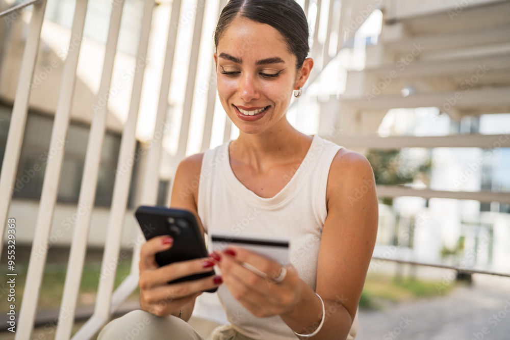 Young woman sit on stairs buy online on cellphone and credit card Young woman sit on stairs buy online on cellphone and credit card