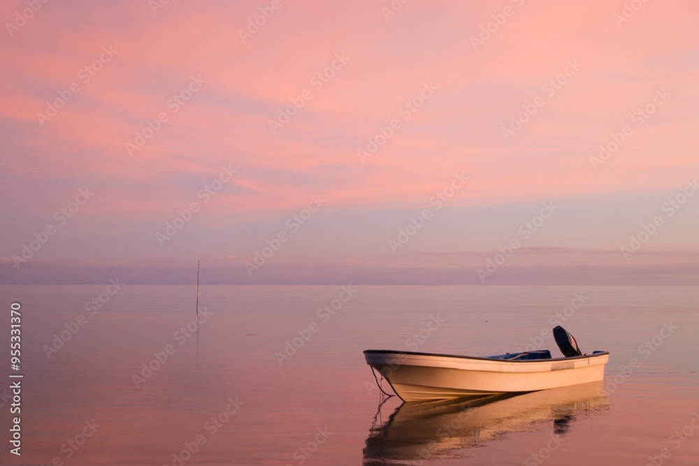 Small boat in front of a deep purple sky reflecting in the sea. Full purple sky with almost no horizon. Stunning evening sky just after sunset. Yasawa Islands tranquility. Invisible horizon. Fiji. Small boat in front of a deep purple sky reflecting in the sea. Full purple sky with almost no horizon. Stunning evening sky just after sunset. Yasawa Islands tranquility. Invisible horizon. Fiji.