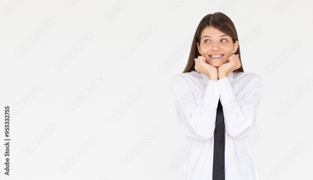 Headshot of pleased high spirit pretty female model, has warm pleasant smile, keeps hands under chin, wears white shirt, isolated over white background. Happiness concept Headshot of pleased high spirit pretty female model, has warm pleasant smile, keeps hands under chin, wears white shirt, isolated over white background. Happiness concept