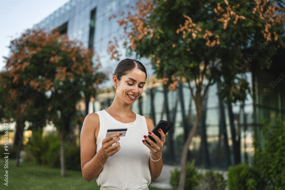 Young woman stand outdoor and buy online on cellphone with credit card Young woman stand outdoor and buy online on cellphone with credit card