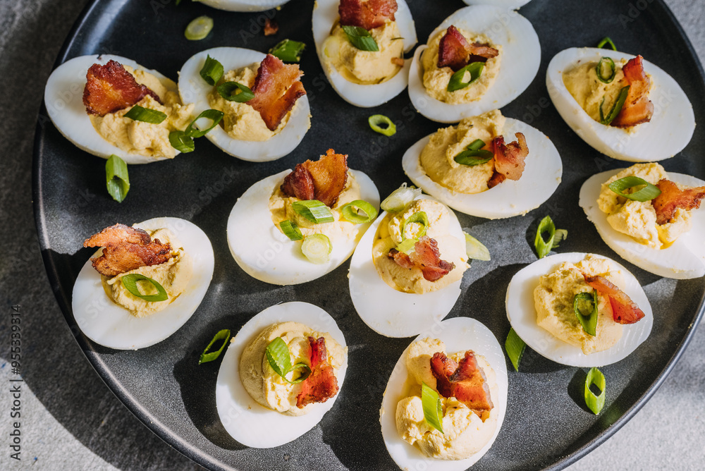 Deviled eggs garnished with bacon and green onion Deviled eggs garnished with bacon and green onion
