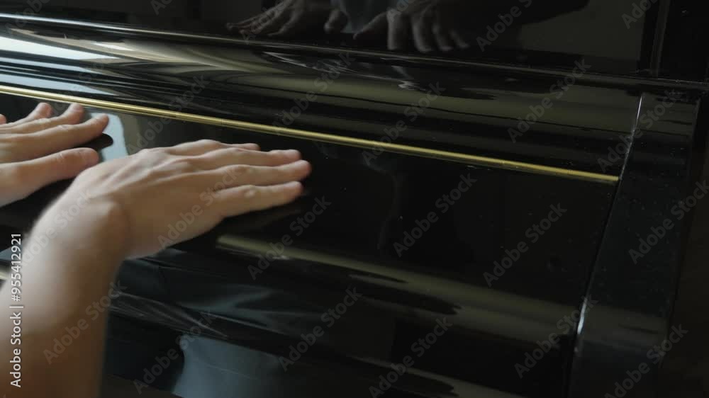 Close up pianist hands stroke the lid of the piano and open musical instrument. Musician studying to play the piano Close up pianist hands stroke the lid of the piano and open musical instrument. Musician studying to play the piano
