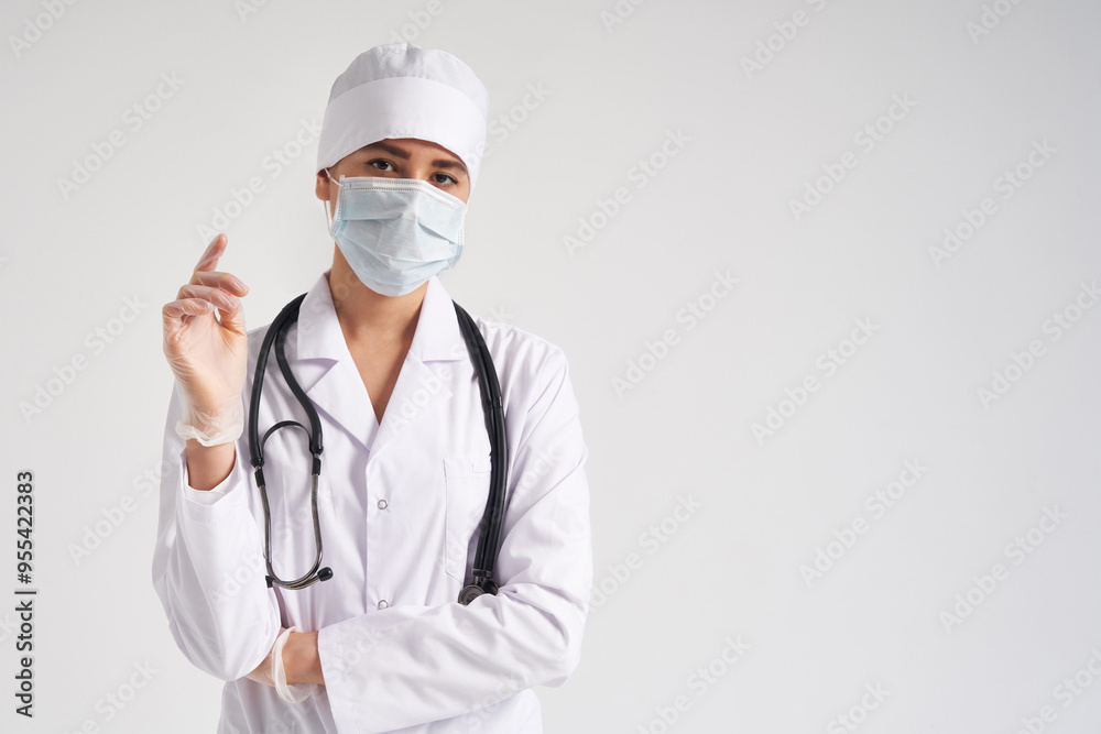 Young doctor wearing surgical gloves and facial mask , studio shot over white background with copy space Young doctor wearing surgical gloves and facial mask , studio shot over white background with copy space