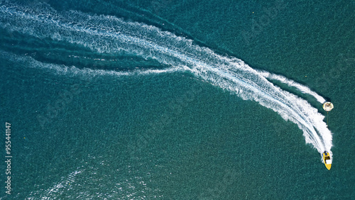 Vertical Aerial View of Deep Blue Sea Water with Yacht and Boat Leaving White Foamy Trail