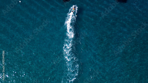 Vertical Aerial View of Deep Blue Sea Water with Yacht and Boat Leaving White Foamy Trail