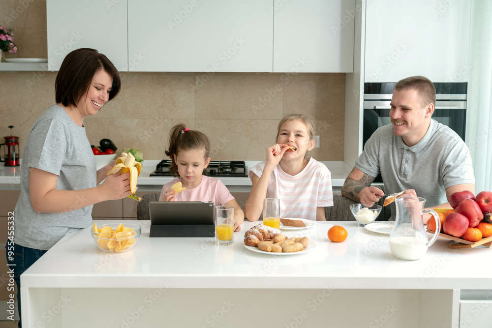 Smiling Family Dining Together at kitchen table and having fun, parents with two daughters Smiling Family Dining Together at kitchen table and having fun, parents with two daughters