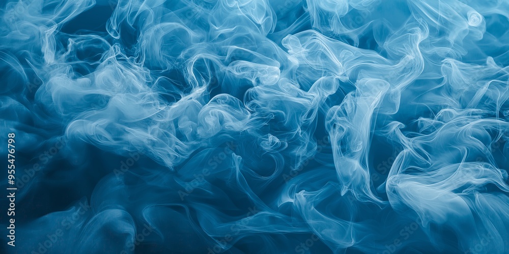 Obraz premium White smoke curls against a blue background, forming abstract shapes and creating a dreamy and ethereal visual effect.