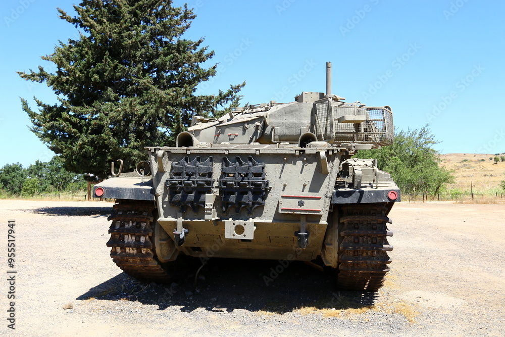 An old tank stands on the side of the road. An old tank stands on the side of the road.